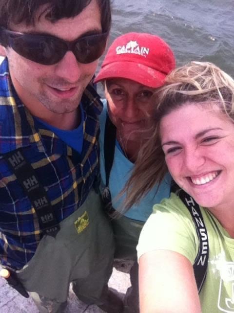 default-47 A family selfie on a boat with a man, woman in 'Captain' cap, and a young woman.